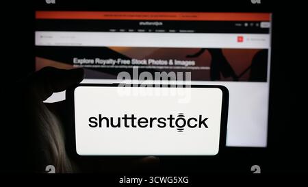 Deutschland. Oktober 2025. In dieser Fotoabbildung hält eine Person ein Handy mit dem Logo des Aktienfotografen Shutterstock Inc. Auf dem Bildschirm vor der Webseite. (Foto von Timon Schneider/SOPA Images/SIPA USA) *** ausschließlich für redaktionelle Nachrichten *** Credit: SIPA USA/Alamy Live News Stockfoto