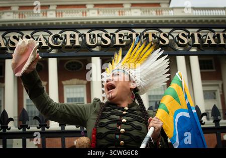 Boston, Massachusetts, USA. 11. Oktober 2025. März zum Tag der indigenen Völker. Chali'Naru Dones, Vereinigte Konföderation der Taino, am Tor des Haupteingangs zum Massachusetts State House am Boston. Die jährliche Demonstration seit 2016 unterstützt die Umstellung des US-Bundesfeiertags von Columbus auf den Tag der indigenen Völker. Der Columbus Day wird am zweiten Montag im Oktober gefeiert. Credit: Chuck Nacke / Alamy Live News Stockfoto