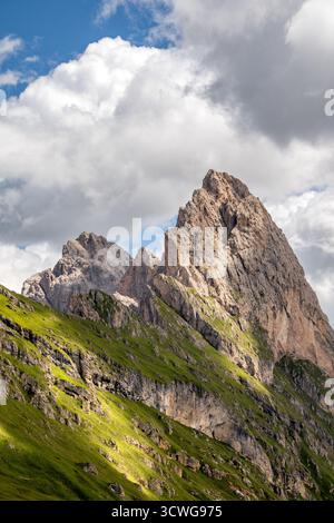 Dramatischer Gipfel von Gran Fermeda und Sass Rigais, der sich in Gröden in den italienischen Dolomiten scharf gegen einen teilweise bewölkten Himmel erhebt Stockfoto