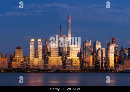 Abendblick auf die Skyline von Midtown West Manhattan. Wolkenkratzer reflektieren das Licht des Sonnenuntergangs am Hudson River, New York City, USA Stockfoto