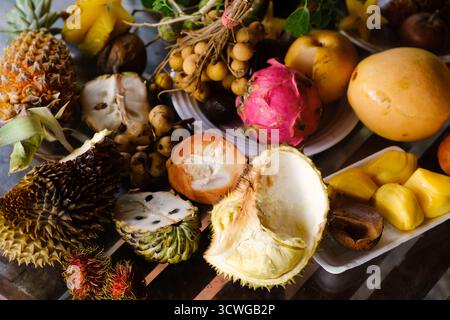 Auf einem lokalen Markt in Südostasien werden verschiedene exotische Früchte auf Tellern serviert. Stockfoto
