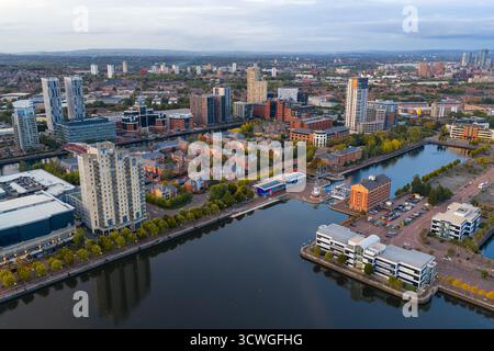 Luftbild der Salford Quays in der Dämmerung mit Blick auf die Skyline von Manchester mit ruhigen Wasserreflexionen. Stockfoto
