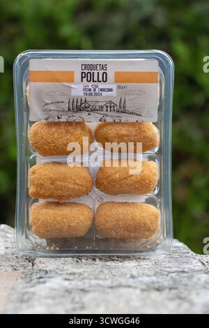 POLLENSA, MALLORCA, SPANIEN - 13. SEPTEMBER 2024 Kunststoffschale mit 8 Pollo-Kroketten Nahaufnahme isoliertes Produkt, das im Freien mit natürlichem Hintergrund entnommen wurde Stockfoto