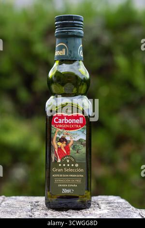 POLLENSA, MALLORCA, SPANIEN - 13. SEPTEMBER 2024 kleine Glasflasche Carbonell Virgen Extra Olivenöl Nahaufnahme isoliertes Produkt, das mit einem im Freien genommen wird Stockfoto
