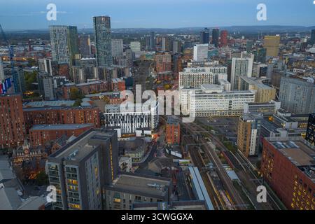 Blick aus der Vogelperspektive über dem Hauptbahnhof Salford mit Blick auf Greengate und das Stadtzentrum von Manchester in der Abenddämmerung Stockfoto