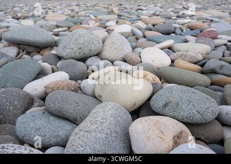 Bunte Kieselsteine am Strand. Texturen und Muster von glatten runden Kiessteinen. Nahaufnahme Stockfoto