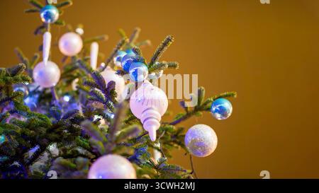 Eine Nahaufnahme eines wunderschön verzierten Weihnachtsbaums mit glänzenden und glitzernden Ornamenten in Silber-, weiß- und Blautönen. Ideal für Themen von Chr Stockfoto