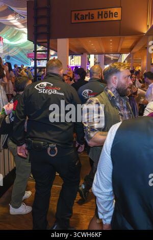 Sicherheitsbeamte in einem geschäftigen Festzelt während einer Party, Cannstatter Wasen Volksfest, Stuttgart, Deutschland Stockfoto