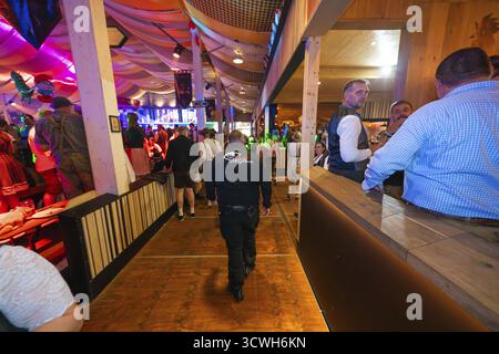 Wachmann in einem gut gefüllten Festzelt mit stimmungsvoller Beleuchtung, Cannstatter Wasen Volksfest, Stuttgart, Deutschland Stockfoto