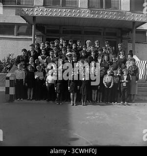Der gefeierte sowjetische Eisbrecherkapitän Anatoly Lamekhov, ein Held der Sowjetunion, posierte in den 1980er Jahren für ein Gruppenfoto mit Schülern und Lehrern an einer Schule in seiner Heimatstadt Sloviansk, der ukrainischen SSR Der dekorierte Polarforscher ist Ehrengast bei einer festlichen Schulversammlung. Kinder jeden Alters in Schuluniformen versammeln sich um den lokalen Helden auf den Stufen des modernistischen Schulgebäudes. Dieses Bild fängt einen Schlüsselmoment der patriotischen Erziehung und des Stolzes der Gemeinschaft ein Stockfoto