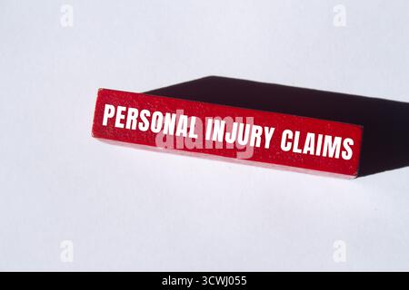 Meldung über Schadenersatzansprüche bei Verletzungen auf Holzblockhintergrund. Symbol für konzeptionelle Personenschäden. Kopierbereich. Stockfoto