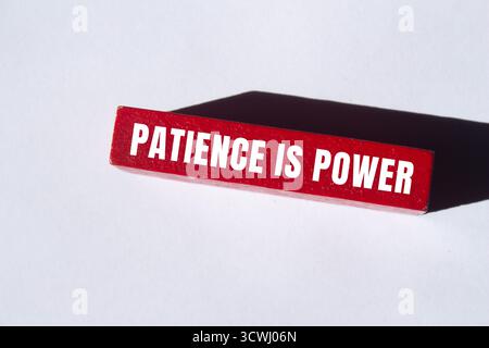 Geduld ist eine Powermeldung auf Holzblockhintergrund. Konzeptionelle Geduld ist ein Machtsymbol. Kopierbereich. Stockfoto