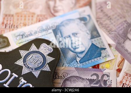 KIEW, UKRAINE - 17. SEPTEMBER 2025 Polizeiabzeichen des Vereinigten Königreichs auf britischen Pfund-Geldrechnungen Nahaufnahme Stockfoto