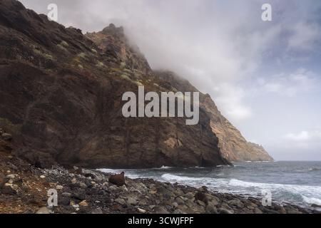 Erkunden Sie die atemberaubenden Klippen und die felsige Küste des Tamadite Strandes auf Teneriffa, während die Wellen sanft gegen die Küste krachen. Stockfoto