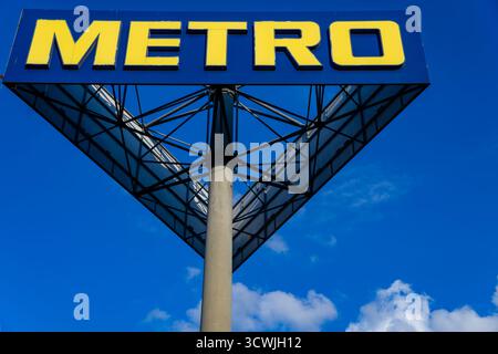Metro Großhandelsgeschäft Schild mit gelbem Logo auf blauem Himmel Hintergrund in Berlin, Deutschland, an einem hellen sonnigen Tag Stockfoto