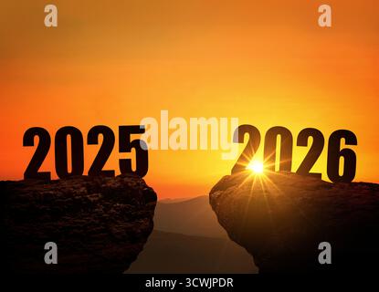 Silvester 2026 am Berg bei Sonnenuntergang, Konzept. 2026 Und 2025 Auf Der Klippe Bei Sonnenaufgang, Kreative Idee. Freier Platz Für Die Konstruktion. Kalender 2026 Stockfoto