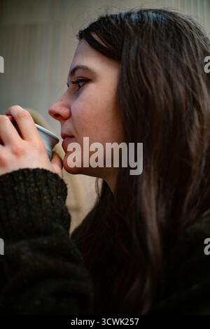 Junge Frau, die auf dem Handy in der Profilansicht spricht Stockfoto