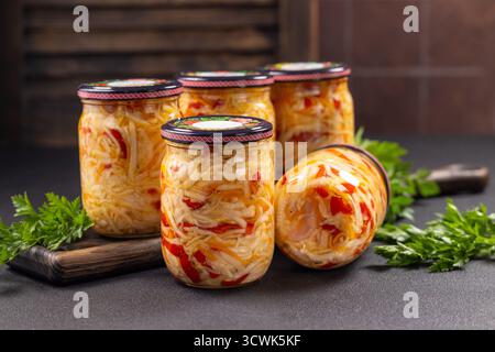Zubereitetes eingelegtes Gemüse, einschließlich gehacktem Kohl, Karotten und Paprika, wird frisch in Glasgläsern konserviert und präsentiert ein herzhaftes und gesundes Stockfoto