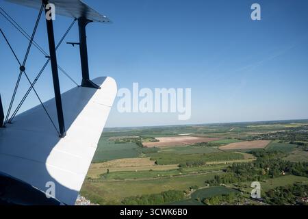Blick aus der Vogelperspektive aus dem Vintage-Doppeldecker-Cockpit über die Landschaft von Cambridgeshire in der Nähe von Duxford Stockfoto