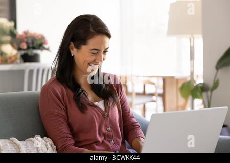 Glückliche junge hispanische Freiberuflerin, die zu Hause arbeitet Stockfoto