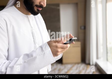 Nahaufnahme junger arabischer Männer in traditioneller islamischer Kleidung mit Telefon Stockfoto