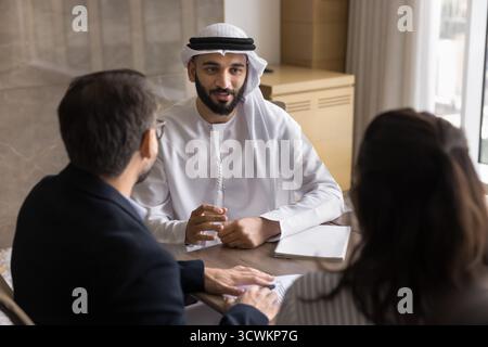 Junger arabischer Mann, der ein Bewerbungsgespräch mit europäischen Paaren führt Stockfoto