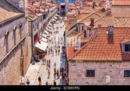 Ein Blick aus der Höhe über Stradun, die wichtigste Fußgängerzone in der Altstadt von Dubrovnik, die von Touristen unter den Terrakottadächern der historischen Altstadt wimmelt Stockfoto