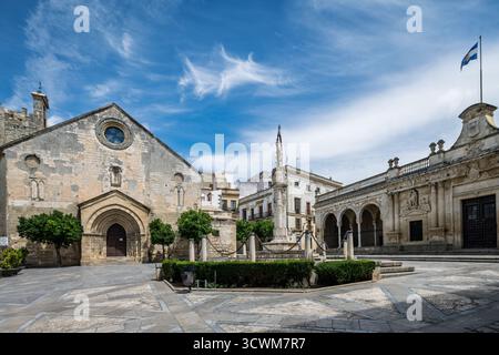 Besucher bewundern die gotisch-Mudéjar-Kirche San Dionisio und das Renaissance Cabildo auf der belebten Plaza de la Asuncion unter einem hellblauen Himmel. Stockfoto