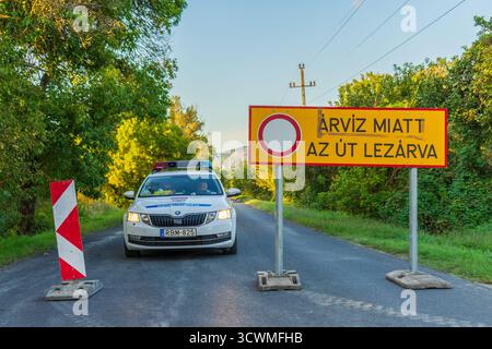 Die Straße wurde von der Polizei gesperrt, da das Hochwasser das Warnschild „Árvíz miatt az út lezárva“ an einer ungarischen Landstraße aufzwingt. Stockfoto