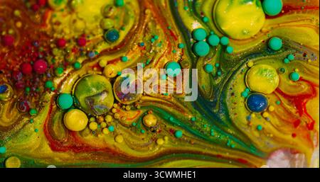 Glitzerspritzer. Tintenölmischung. Defokussierte gelbe grüne rote Farbe sprudelnde Wasserstruktur runde Blasen schwimmende abstrakte Kunst Hintergrund. Stockfoto