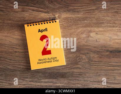 Tischkalender mit dem 2. April, dem Tag des Bewusstseins für den Autismus auf einem Holztisch. Stockfoto