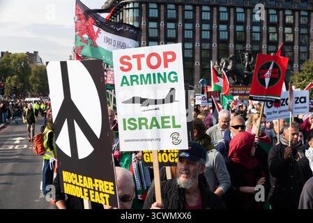 Nationale Demonstration für Palästina Protest in Westminster, London, Großbritannien. Hör auf, Israel-Plakat mit IDF McDonnell Douglas F-15-Kampfflugzeug zu bewaffnen. PSC Stockfoto