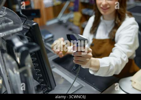 Eine Frau verwendet aktiv einen Barcode-Scanner in einem Einzelhandel Stockfoto