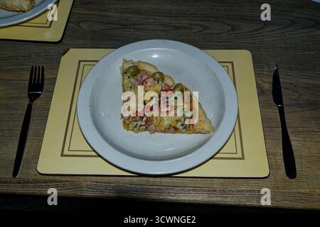 Eine Margherita Pizza-Basis mit zusätzlichen Zutaten – zwei Scheiben, die nach dem Kochen serviert werden können. Stockfoto