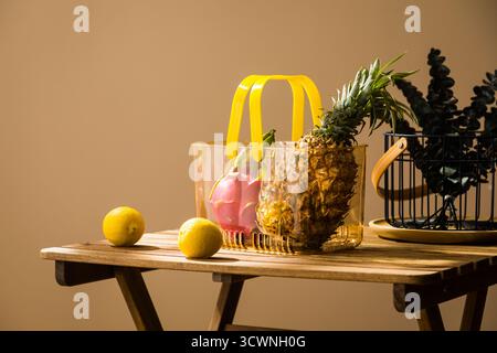 Frische tropische Früchte und Zitronen auf einem Holztisch, Ananas, Zitrone und Minze im Glas auf einem Holztisch Stockfoto