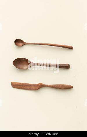 Handgefertigtes Holzlöffel- und Messerset, Holzlöffel auf weißem Hintergrund. Flache Lage, Draufsicht. Stockfoto