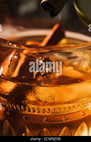 Nahaufnahme eines goldenen Whiskygetränks mit Eis und Zimt Stockfoto