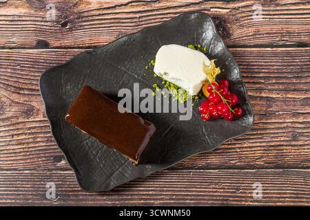 Kräftiger Schokoladenbrownie mit Vanilleeis und Beeren Stockfoto