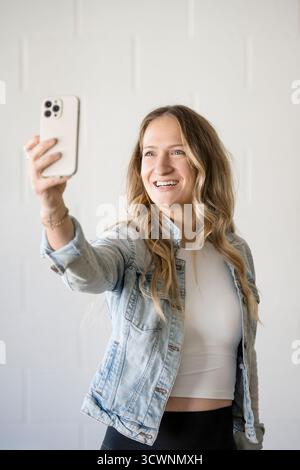 Lächelnde Frau macht Selfie bei natürlichem Licht Stockfoto