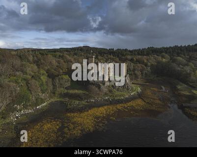 Blick aus der Vogelperspektive auf eine mittelalterliche Burg, die stolz auf einem Felsvorsprung steht, eingerahmt von tiefgrünen Wäldern und dem stimmungsvollen Blau des Meeres, Edimburg, Schottland. Stockfoto