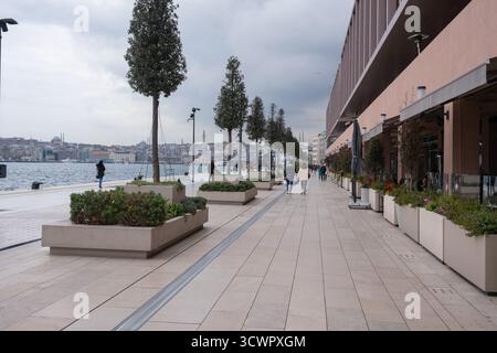 Istanbul, Türkei - 10. März 2023: Breiter Fußweg entlang der Uferpromenade von Galataport mit Blick auf die Skyline der Stadt und den Bosporus Stockfoto
