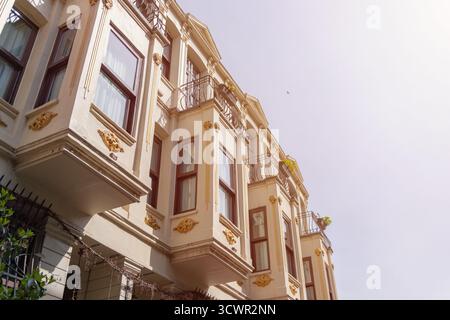 Reihe historischer, cremefarbener Gebäude mit verzierten Balkonen und Fenstern. Wunderschönes Gebäude mit komplizierten Details und warmer, einladender Fassade Stockfoto