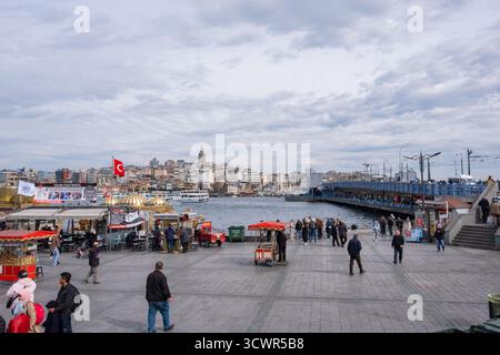 Istanbul, Türkei - 10. März 2023: Menschen gehen auf dem Eminonu-Platz in Istanbul, mit der berühmten Galata-Brücke und dem Goldenen Horn. Historischer Blick auf Wa Stockfoto