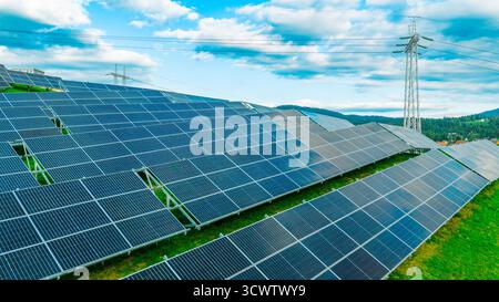 Großes Solarkraftwerk am Hang mit Metallkonstruktionen und blauem Himmel Stockfoto