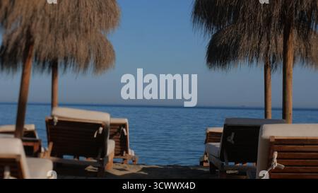 Sonnenliegen und Sonnenschirme am Strand Al Caideasa in Südspanien. Stockfoto