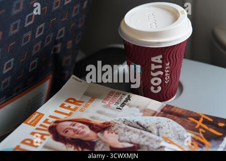 Costa Coffee Becher und EasyJet Traveller Bordmagazin auf einem Tablett-Tisch während des Fluges in der Flugzeugkabine. München, Deutschland Stockfoto