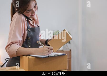Startup Kleinunternehmer KMU, asiatische Frau erhält telefonisch Bestellung. Erfolg junger asiatischer Kleinunternehmer, Inhaber Home Office, Online-Verkauf Stockfoto