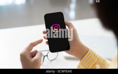 CHIANG Mai, THAILAND - 26. August 2025: Eine Frau hält Apple iPhone 14 pro mit Instagram-Anwendung auf dem Bildschirm im Café. Instagram ist ein Foto-Sharing Stockfoto