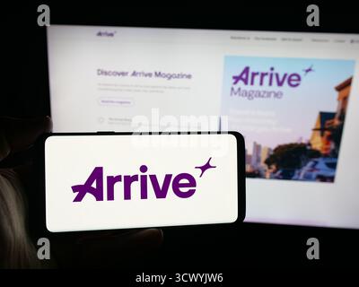 Stuttgart, Deutschland - 10.09.2025: Person, die ein Smartphone mit dem Logo des schwedischen Unternehmens für intelligente Mobilität hält, kommt auf dem Bildschirm vor der Website an. Stockfoto