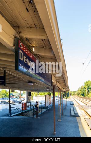Ein Bahnhof Devon mit einem Schild mit der Aufschrift 'Sepia Devon'. Die Station ist leer und der Himmel ist klar, Philadelphia, USA Stockfoto